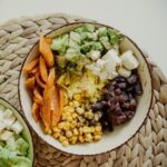 Top view of vegetarian bowls with avocado, corn, beans, and cheese for a delicious meal.